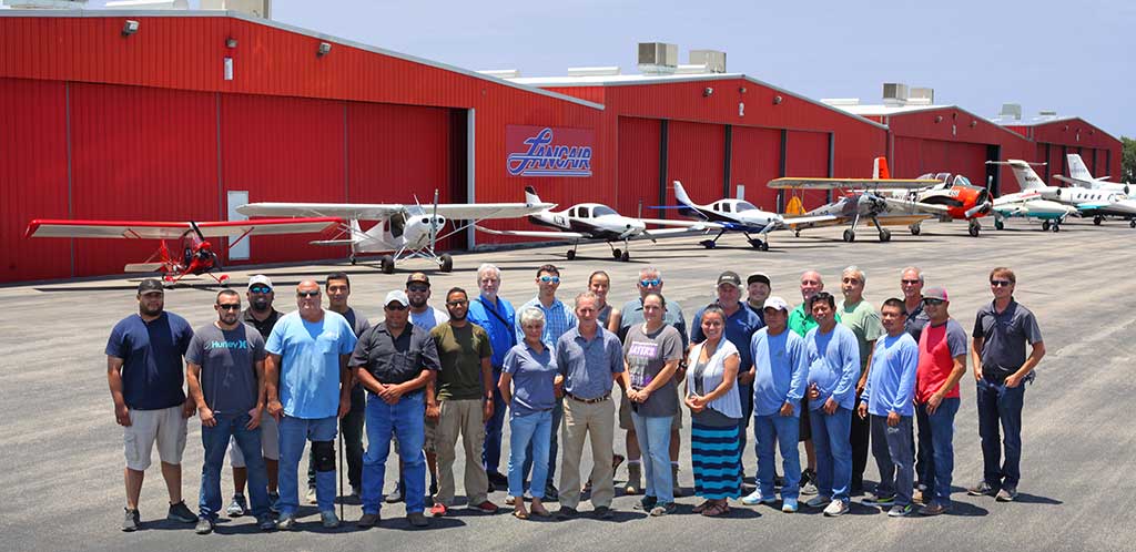 Lancair International staff in front of hangars